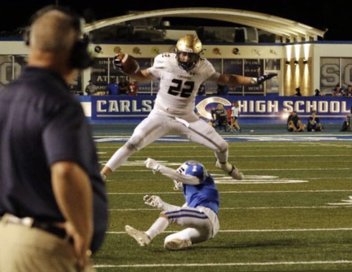 Cox hurdles a Carlsbad defender on his way to a first down.